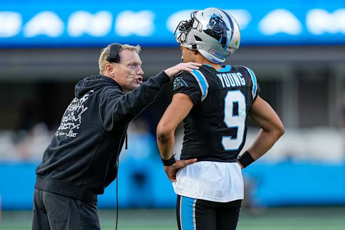 Chris Tabor puts a hand on Bryce young’s shoulder as he leans over talking to him